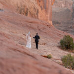Bride and groom holding hands in the Moab Utah Desert