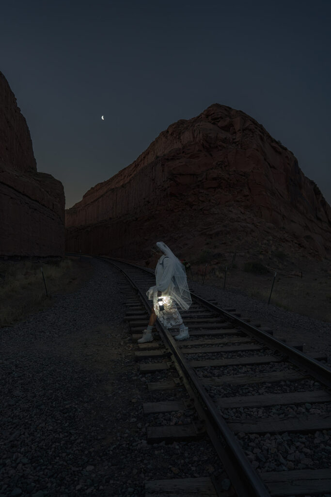 Bride walking at night with a lantern at a Moab Utah Elopement