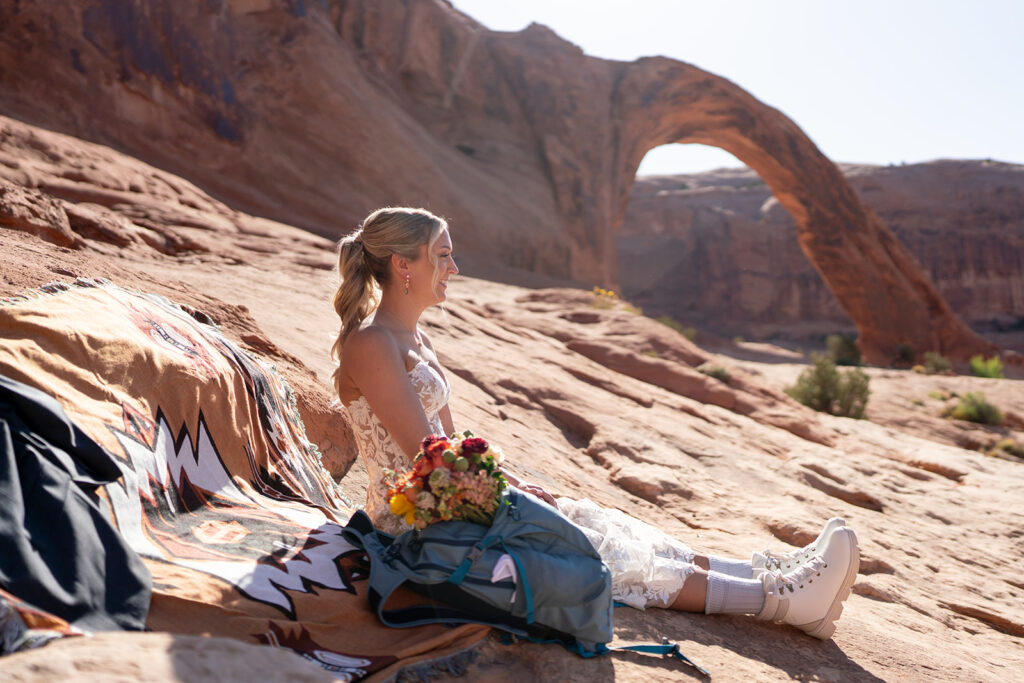 Bride sitting in the Moab Desert in Utah near the Arches