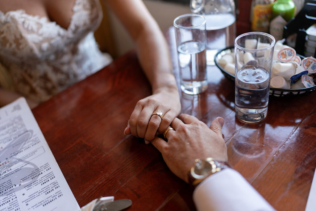Newly weds showing their rings at dinner at Cactus Jack's after their Desert elopement