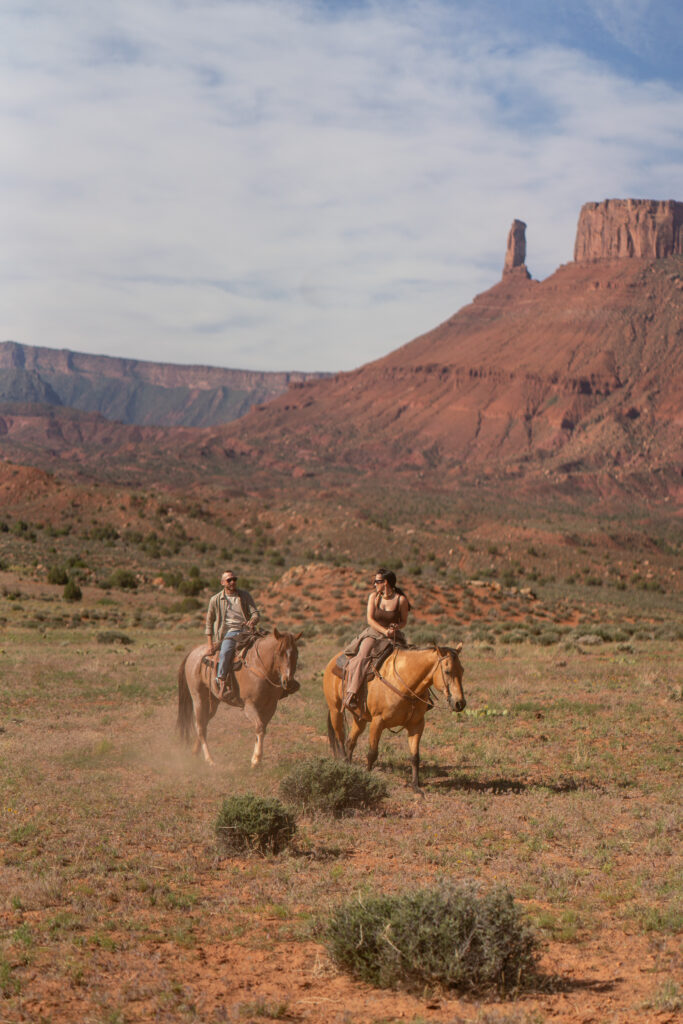Horseback riding in canyon at sunrise — Couple riding horses through a private canyon trail during their Moab, Utah elopement.