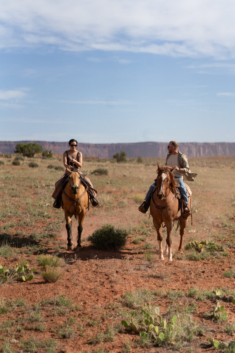 Horseback riding in canyon at sunrise — Couple riding horses through a private canyon trail during their Moab, Utah elopement.