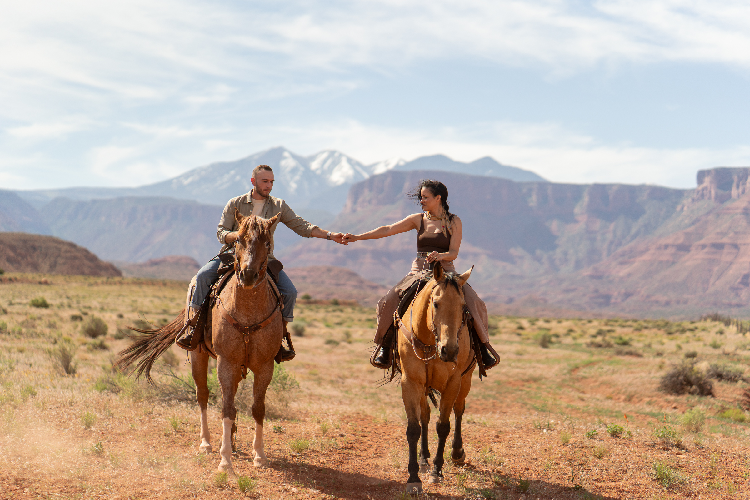 Horseback riding in canyon at sunrise — Couple riding horses through a private canyon trail during their Moab, Utah elopement.