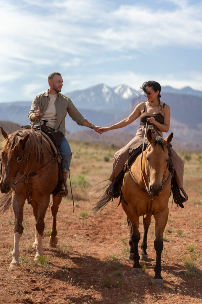 Horseback riding in canyon at sunrise — Couple riding horses through a private canyon trail during their Moab, Utah elopement.