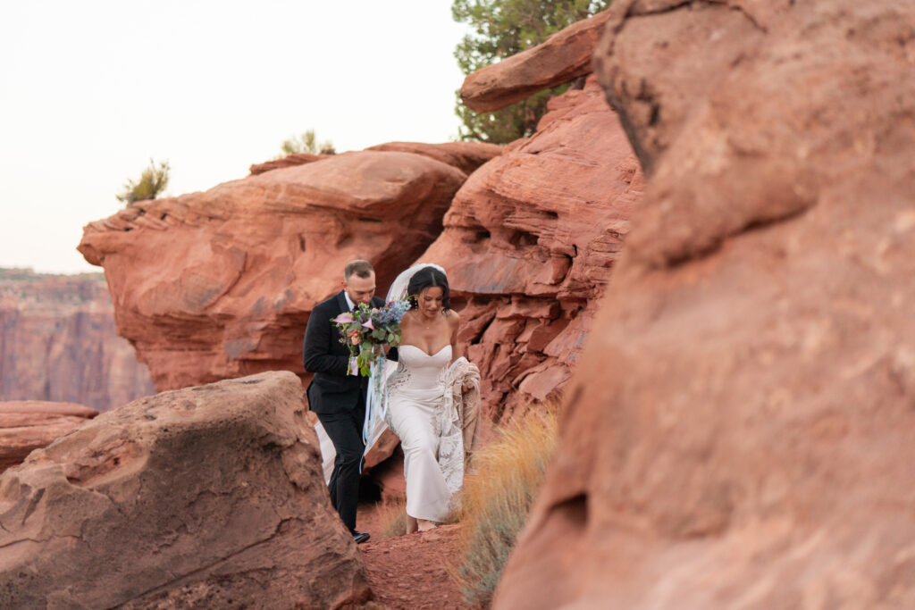 adventurous newly weds walking through the red rocks of Moab Utah on their elopment