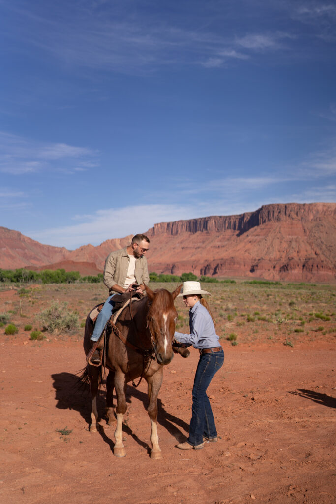 Horseback riding in canyon at sunrise — Couple riding horses through a private canyon trail during their Moab, Utah elopement.