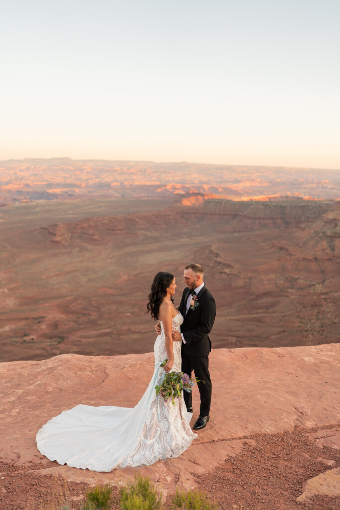 Bride and groom on the red cliffs of Moab utah