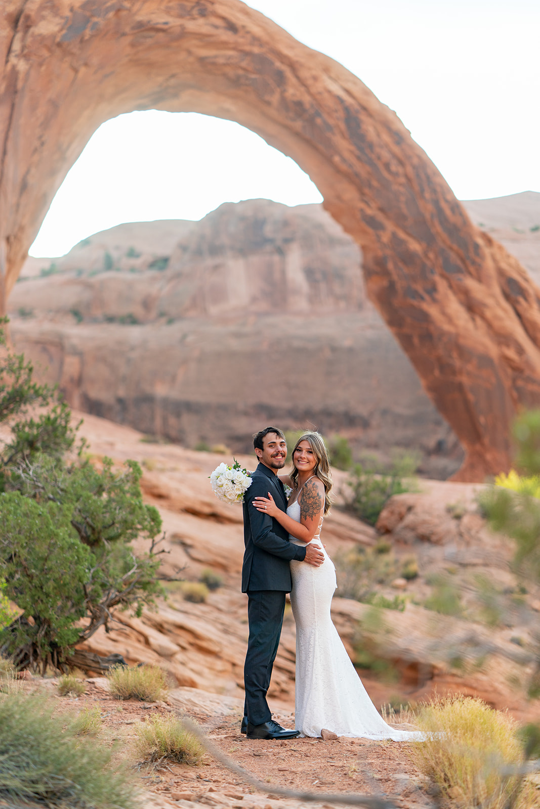 Couple posing at sunrise at Arches National Park elopement
