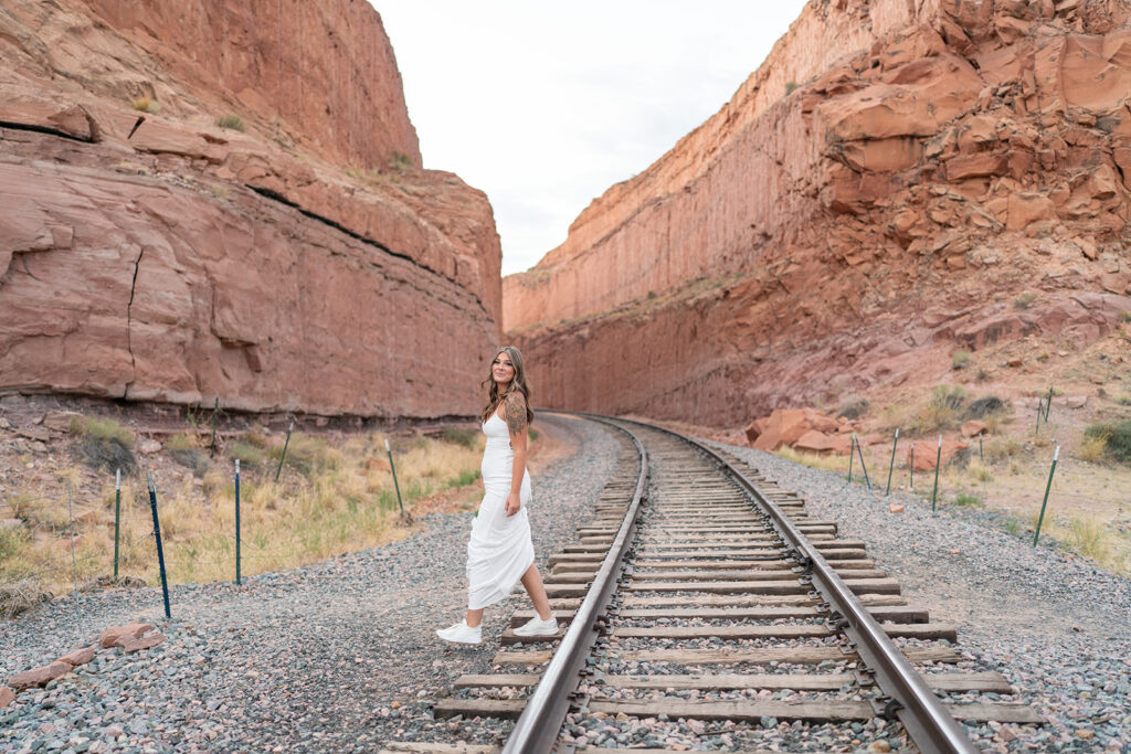 Bride posing at railroad tracks at Arches National Park elopement