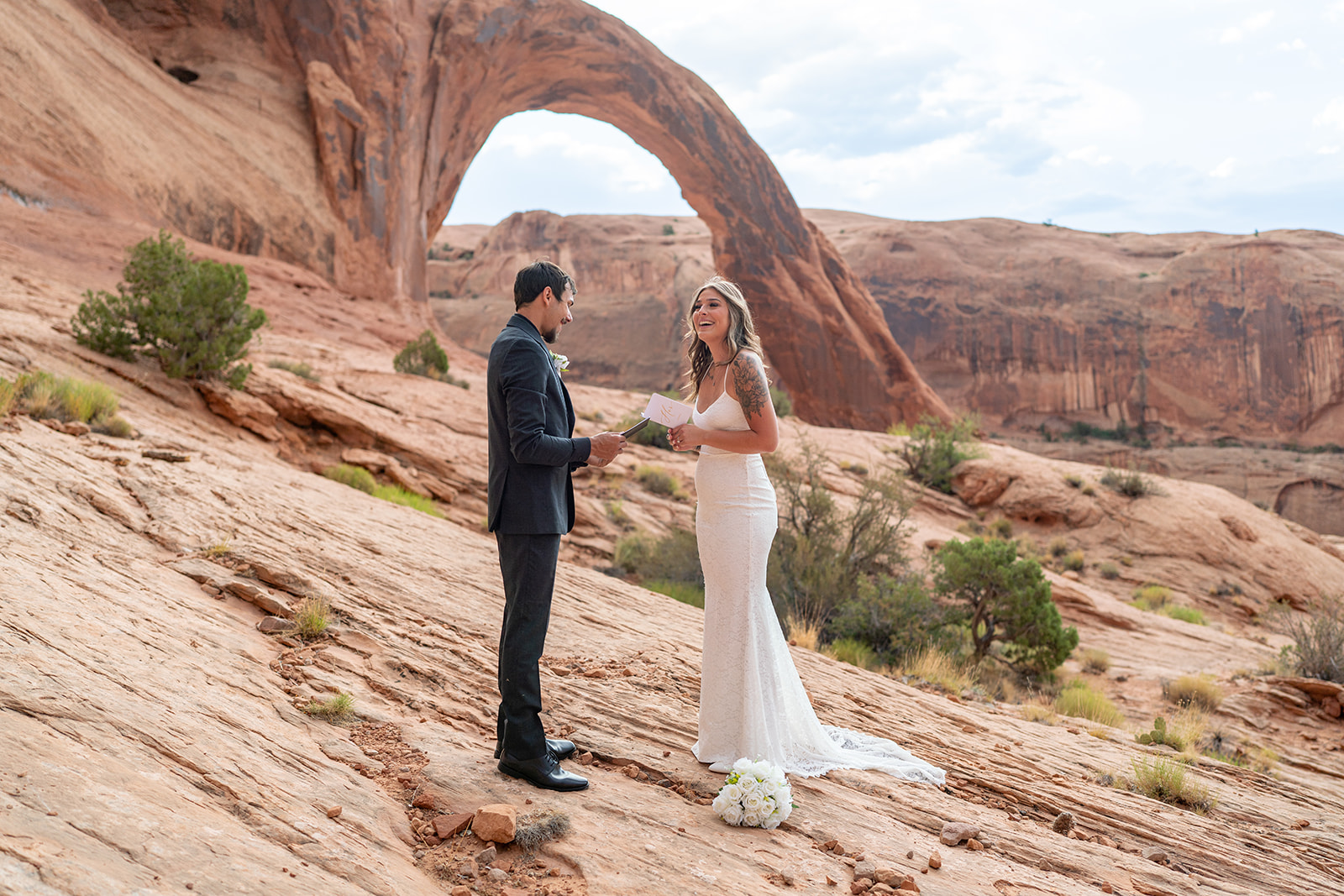Bride and groom exchanging vows with witnesses at Arches National Park elopement