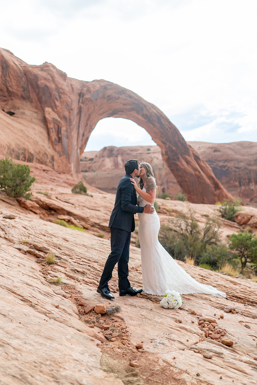 Couple kissing at sunrise during Moab Utah elopement ceremony