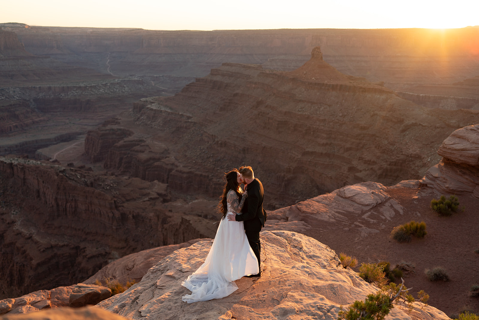 with the Utah canyon landscape visible in the background, a beautiful setting for an elopement.